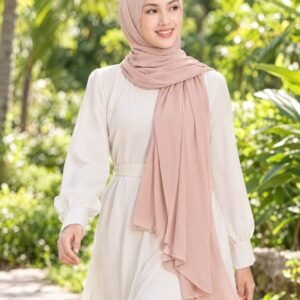 Woman walking through a tropical garden in a blush-pink shawl